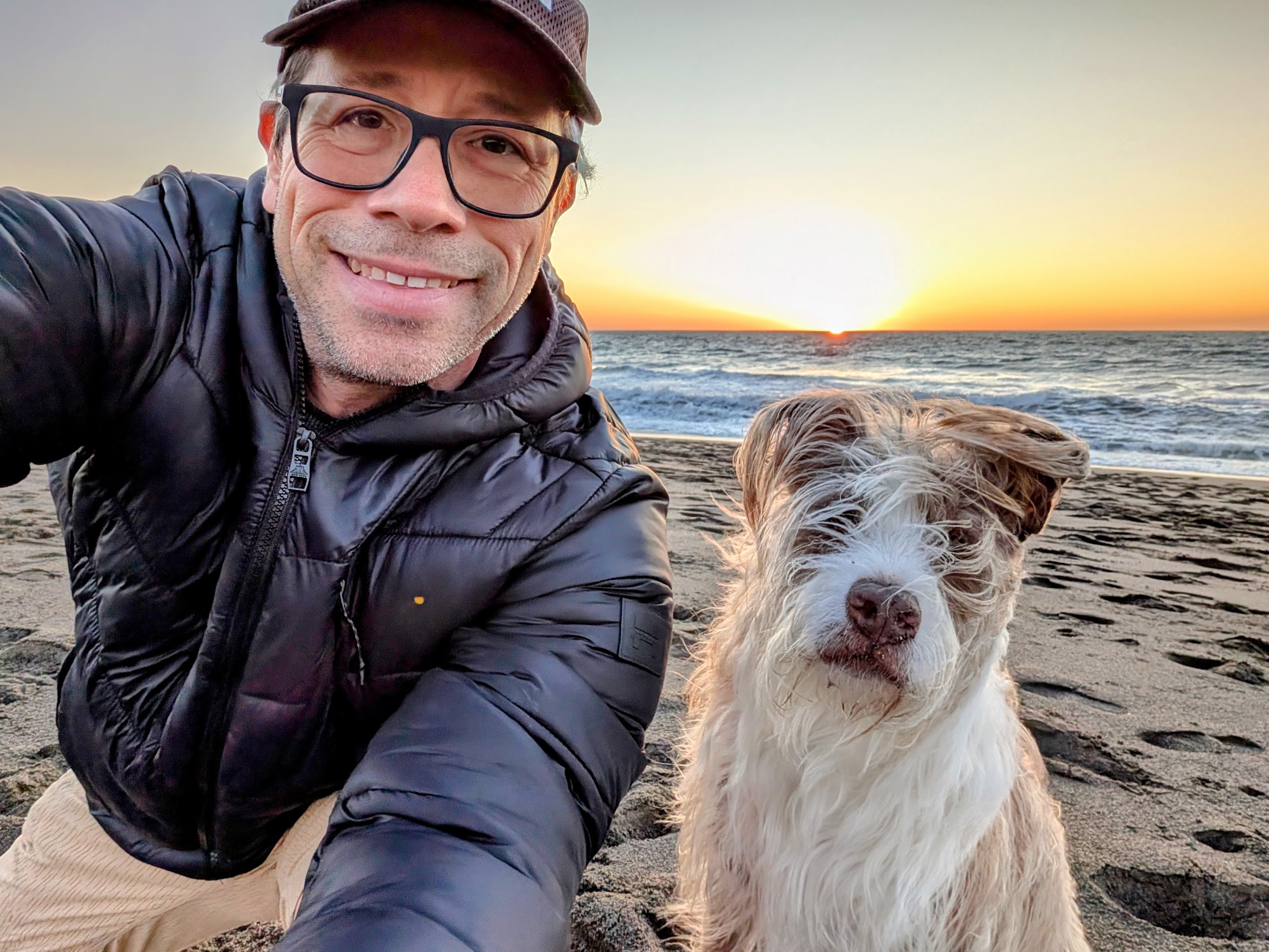 Matthew Reyes and his dog Sal at sunset on the beach